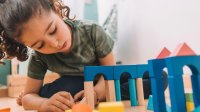 Preschool student playing with building blocks