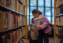 Two students picking out books at the library