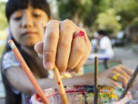 A photo of an elementary-school girl painting in art class.